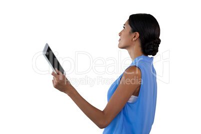 Side view of businesswoman holding tablet while looking away