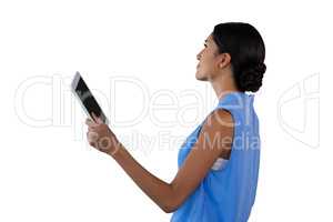 Side view of businesswoman holding tablet while looking away