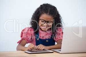 Smiling businesswoman using tablet while sitting at desk