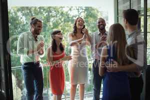 Group of friends applauding couple during party