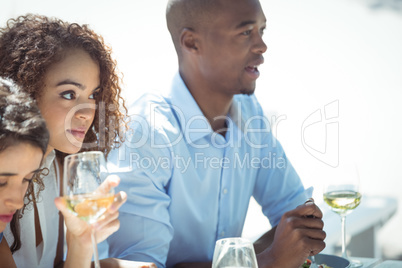 Happy friends interacting while having glass of wine