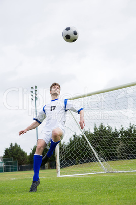 Full length of soccer player playing with ball