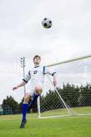 Full length of soccer player playing with ball