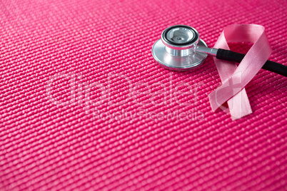 High angle view of pink Breast Cancer Awareness ribbon with stethoscope