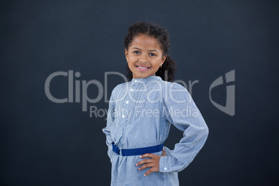 Portrait of happy girl with hand on hip