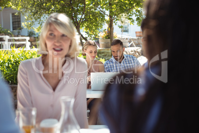 Friends using laptop in restaurant