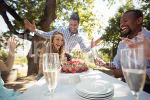 Group of friends celebrating womans birthday at outdoor restaurant