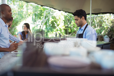 Male waiter taking order at counter