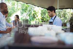 Male waiter taking order at counter