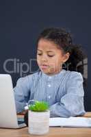 Businesswoman using laptop against black background