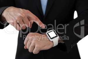 Mid section of businessman pointing on smart watch