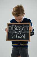 Schoolboy holding slate with text against white background