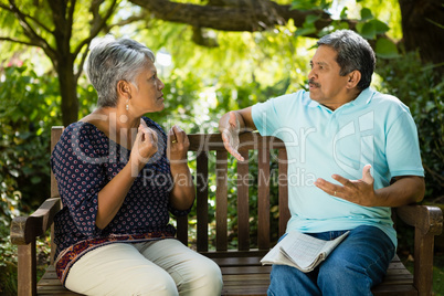 Senior couple arguing while sitting on the bench