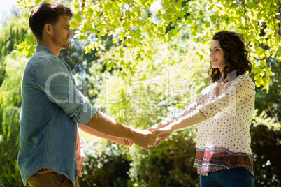 Romantic couple holding hands in garden