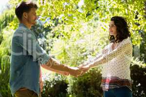 Romantic couple holding hands in garden