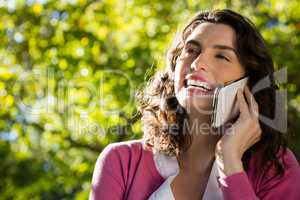 Woman sitting on bench and talking on mobile phone