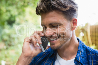 Man talking on mobile phone in garden on a sunny day