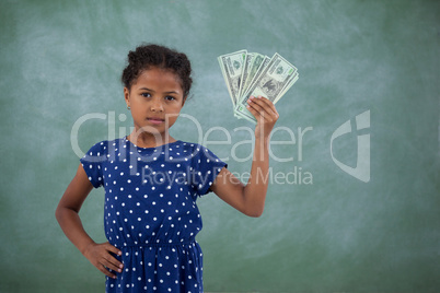 Portrait of girl with hand on hip showing paper currency