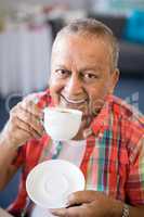 Portrait of smiling senior man drinking coffee