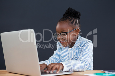 Smiling businesswoman wearing eyeglasses using laptop