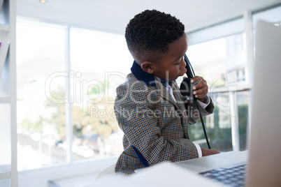 Businessman with laptop discussing on phone in office