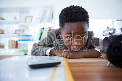 Portrait of bored businessman leaning on desk