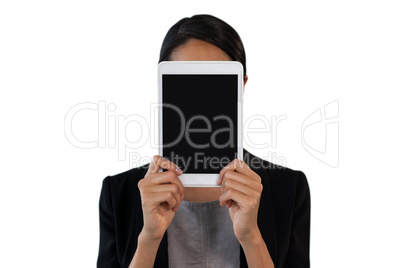 Close up of businesswoman holding tablet computer in front of face