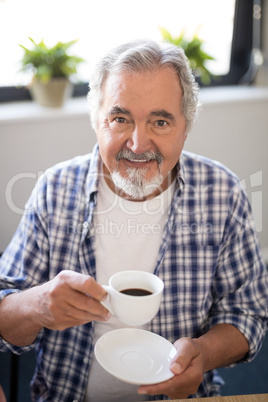 Portrait of smiling senior man holding coffee cup