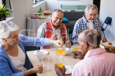 High angle view of woman serving drink to senior friends