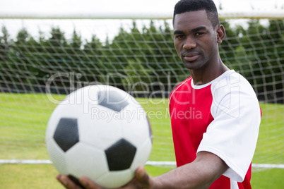 Portrait of male soccer player holding ball