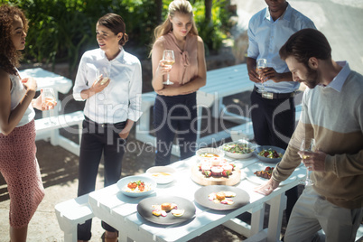 Friends interacting while having glass of wine in restaurant