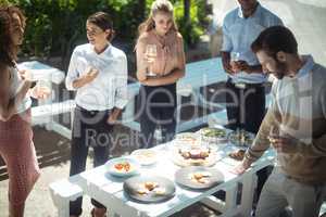 Friends interacting while having glass of wine in restaurant