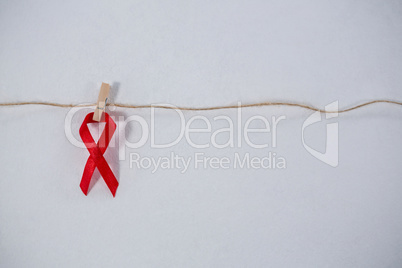 Close-up of red ribbon hanging from clothespin on string