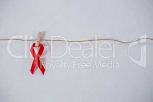 Close-up of red ribbon hanging from clothespin on string