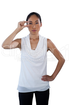 Portrait of serious woman with hand on hip adjusting invisible eyeglasses