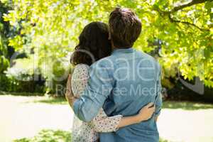 Couple embracing each other in garden on a sunny day