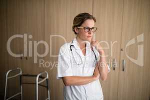 Thoughtful female doctor with hand on chin