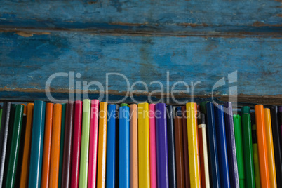 Various color pencils arranged on wooden table