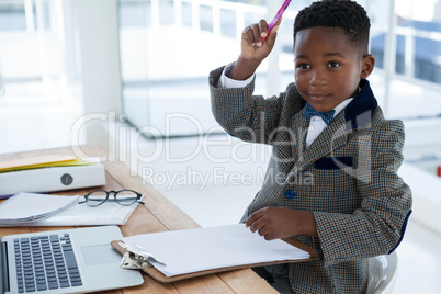 Businessman with arms raised sitting at desk