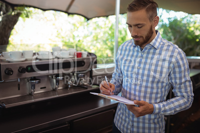 Manager writing note on clipboard