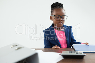 Serious businesswoman looking at files in office