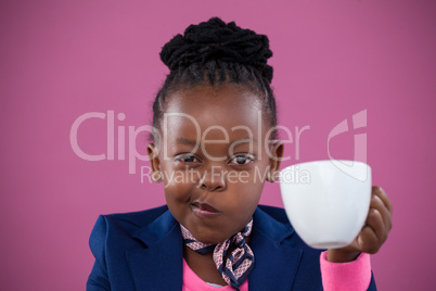 Businesswoman wearing scarf making face while having coffee