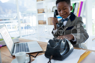 Thoughtful businessman making face while dialing telephone