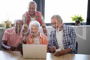 Happy senior people using technology at nursing home