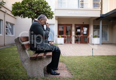 Depressed senior man sitting on bench