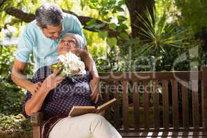 Senior man giving flowers to woman