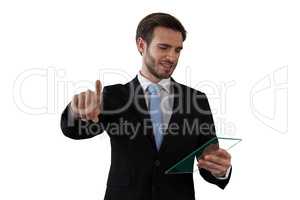 Businessman looking at glass interface while touching invisible screen