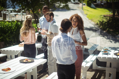 Friends interacting while having glass of wine in restaurant