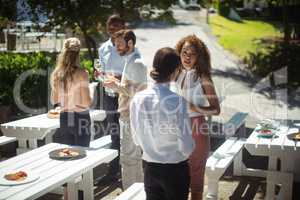 Friends interacting while having glass of wine in restaurant