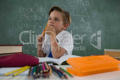 Schoolboy doing his homework in classroom